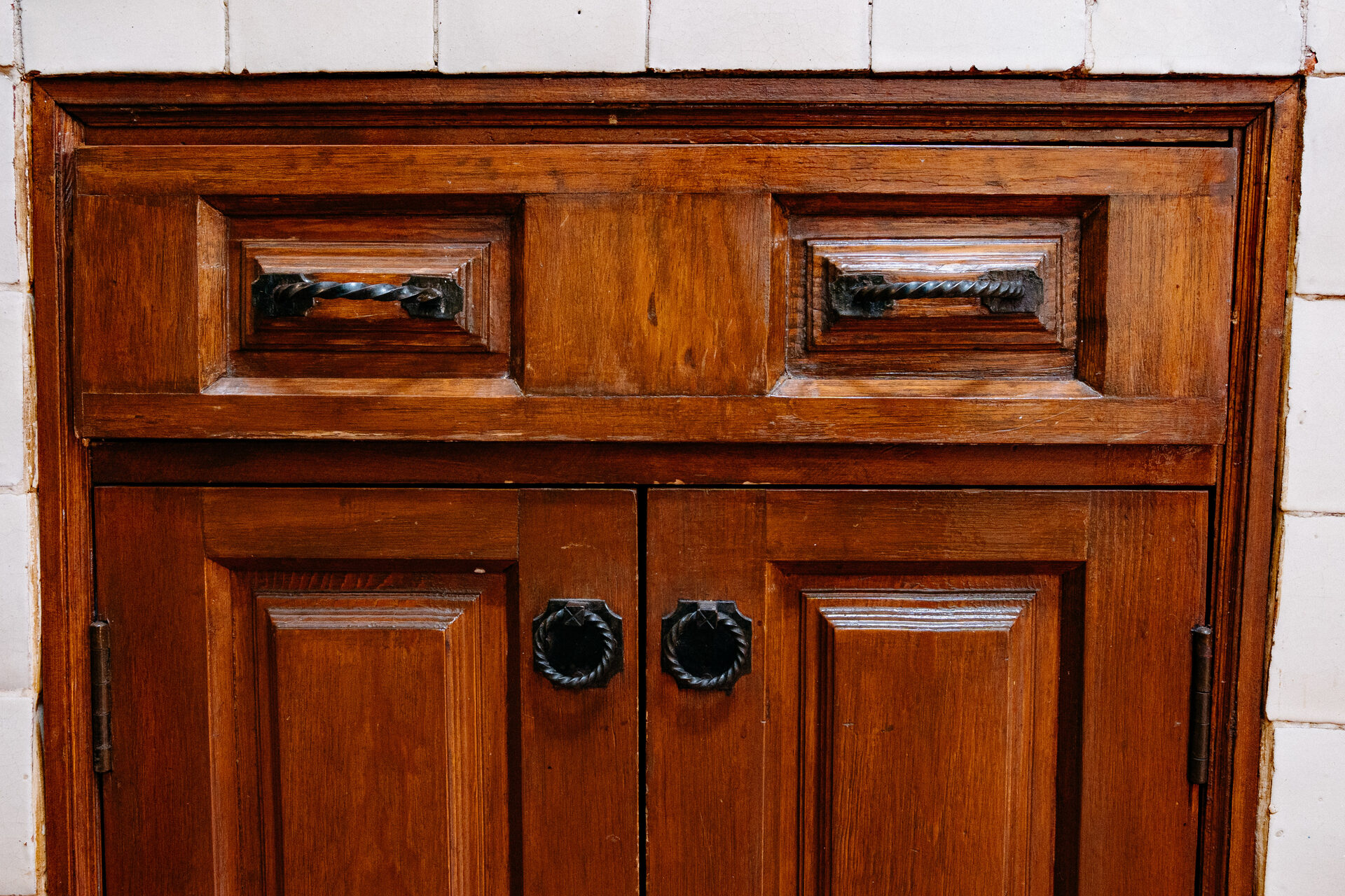 Gabinete de madera maciza tallada con jaladeras de hierro en la cocina de Quinta La Joya
