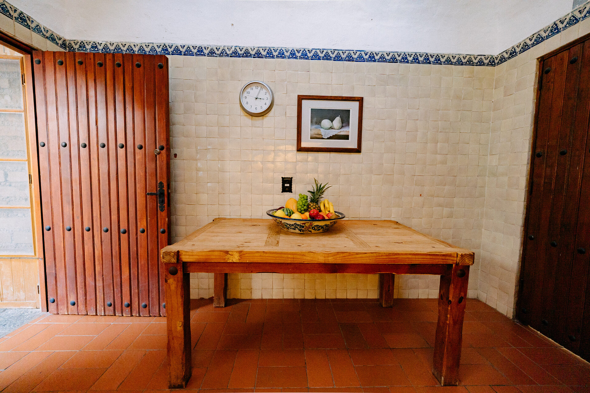 Mesa de trabajo de madera de bloque en la cocina de Quinta La Joya, bajo el reloj y junto a la puerta de servicio