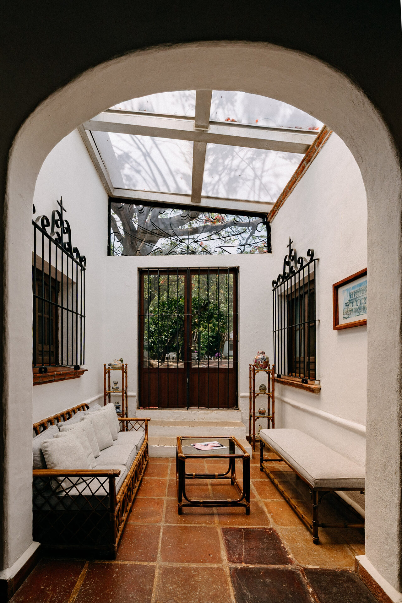 Solarium de Quinta La Joya: cuarto blanco con bóveda de cristal, herrería y puerta de madera hacia el jardín