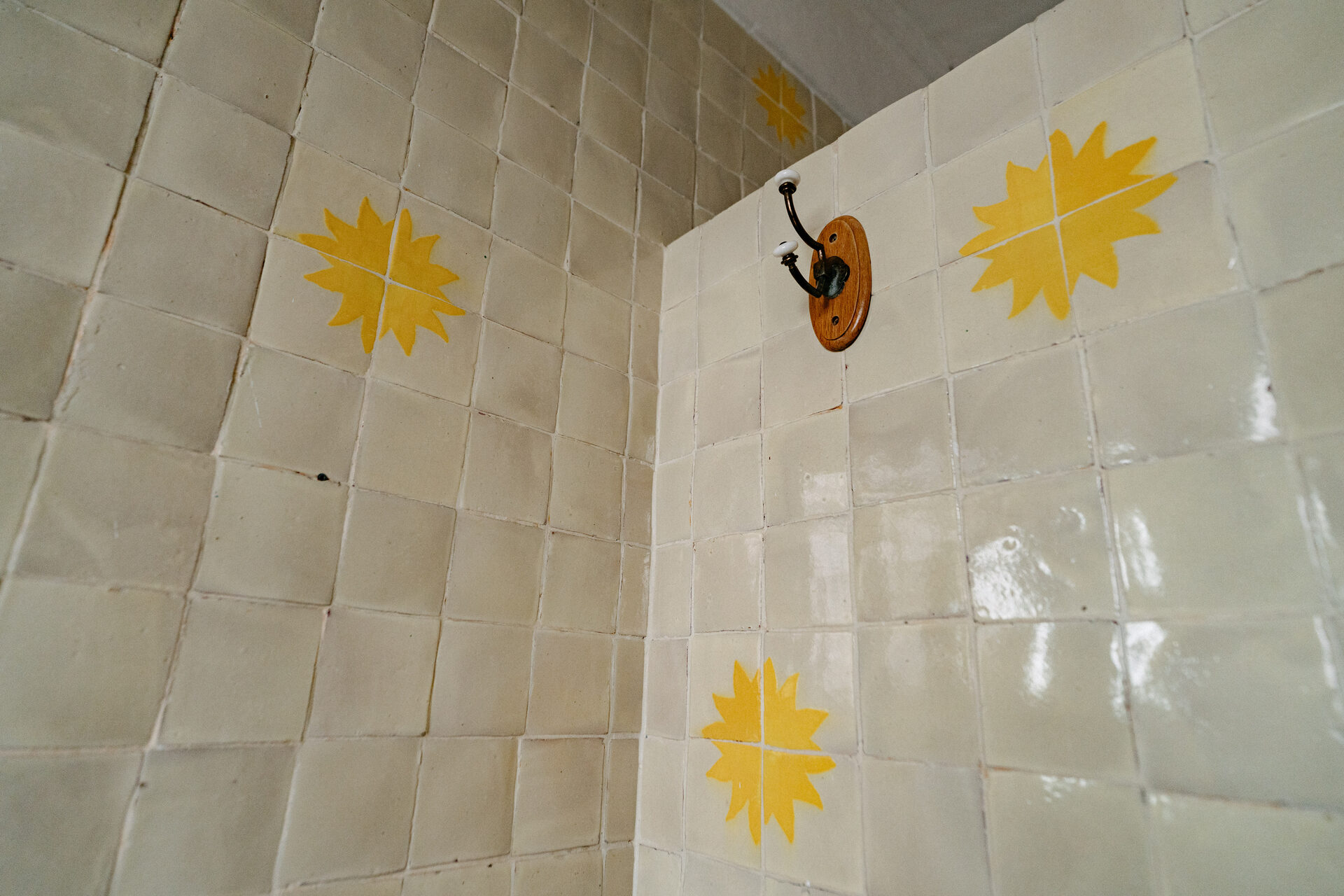 Azulejo pintado a mano con soles amarillos en el baño de la suite 2 de Quinta La Joya